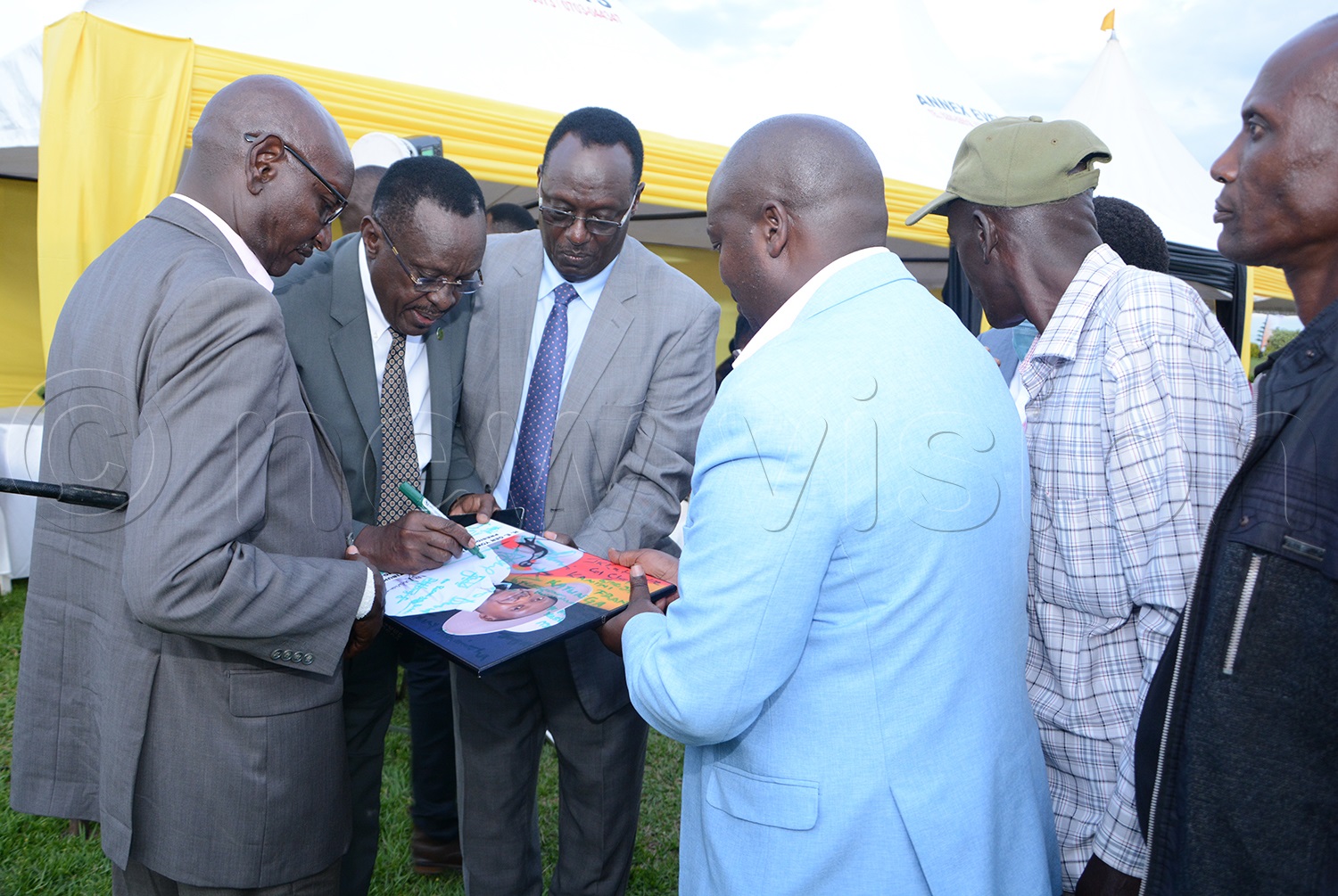 Brig. Sam Bishuba signing the portrait. Photo by Adolf Ayoreka