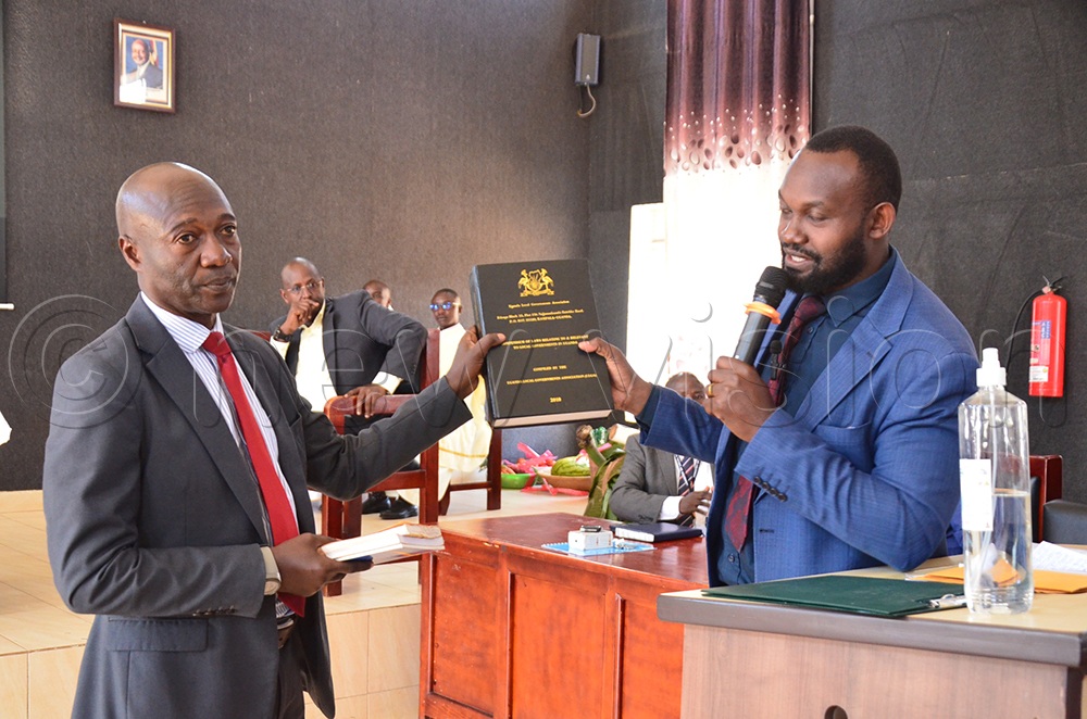 Mugarama (R) hands over to the CAO. (Credit: Jonan Tusingwire)