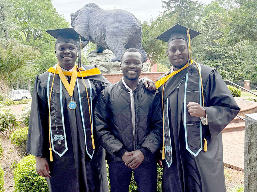 Ibrahim Aliga (left) and Denis Asaba (right) pose with a friend on their graduation day. Courtesy photo