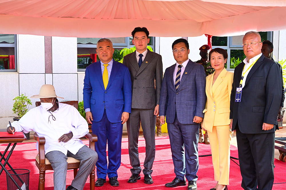 President Museveni signs into the guest book at Sino Mbale Industrial park as Paul Zhanga (L), chairman of Tian Tang group and his team look on during the President's visit to the park to commission a new face. (PPU Photo)