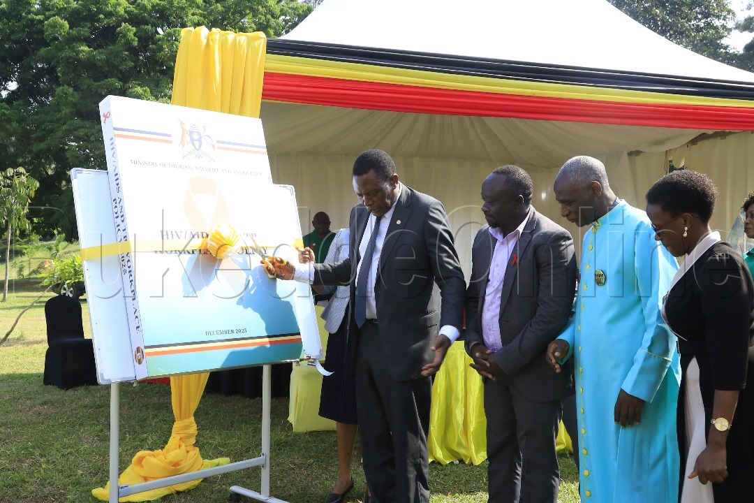 Dr Charles Olaro okuva mu Kitongole kye byobulamu nga ateekako omukono ku kiwandiiko.