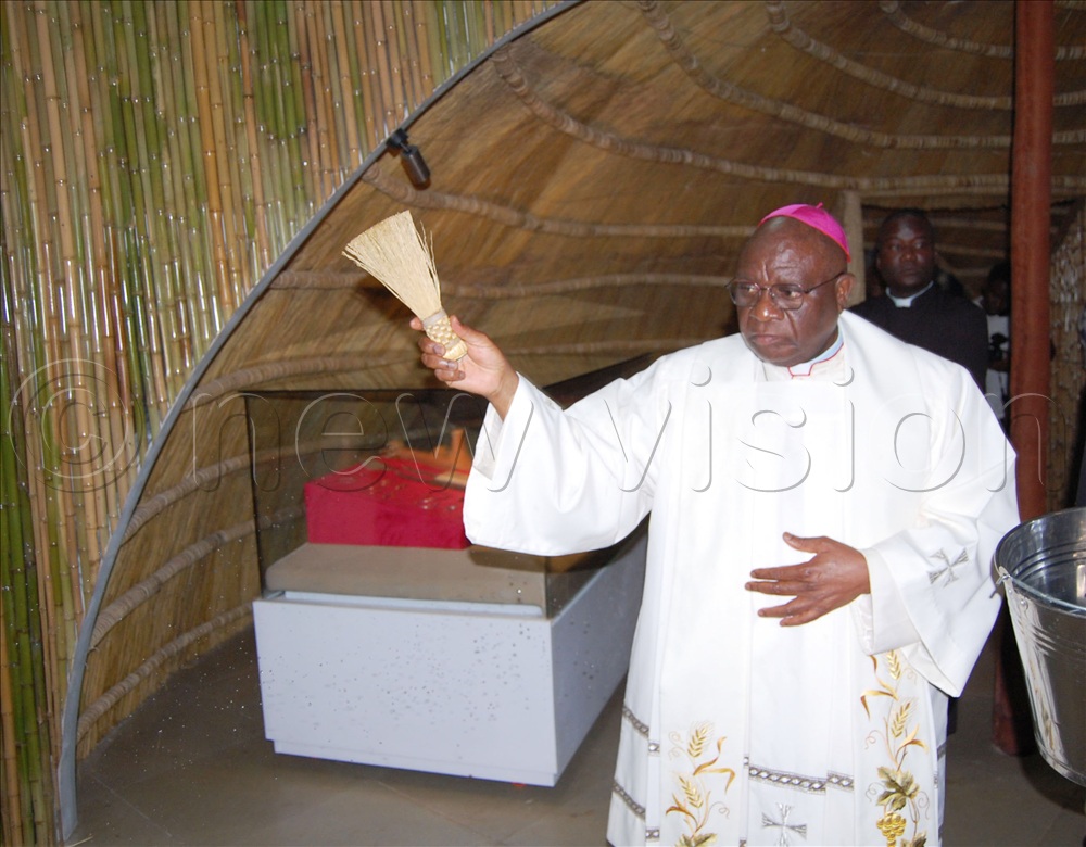 Archbishop Paul Ssemogerere sprinkles holy water into the newly- commissioned museum.
