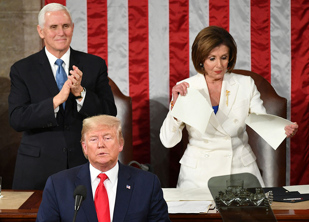 US Vice President Mike Pence claps as Speaker of the US House of Representatives Nancy Pelosi appears to rip a copy of US President Donald Trumps speech after he delivers the State of the Union address at the US Capitol in Washington, DC, on February 4, 2020. (Photo by MANDEL NGAN / AFP)