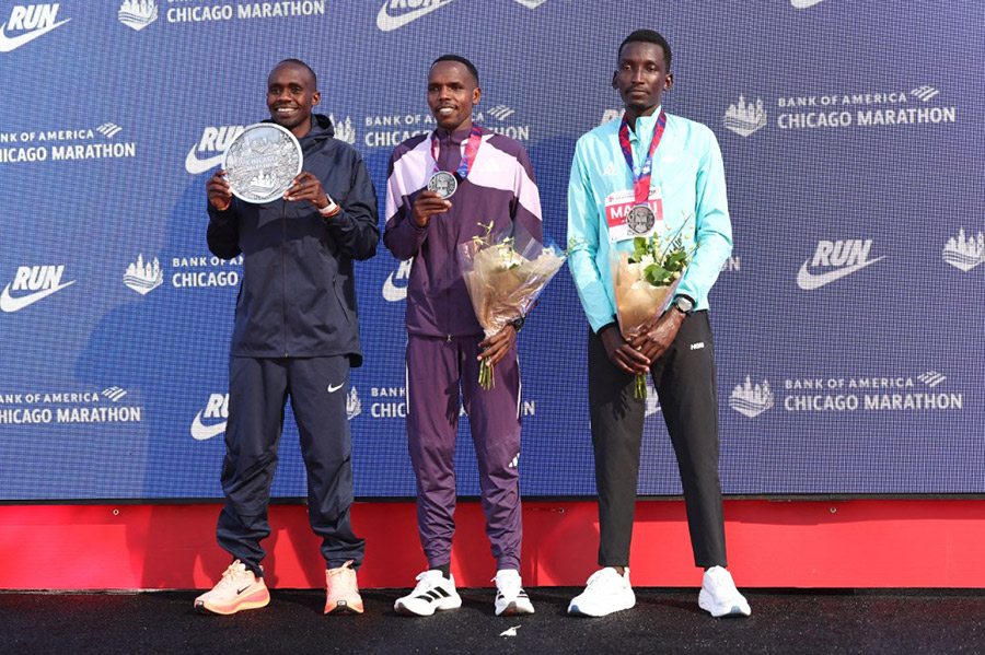 (L-R) 2025 Bank of America Chicago Marathon winner Jacob Kiplimo of Uganda, second place finisher Amos Kipruto of Kenya, and third place finisher Alex Masai of Kenya pose for a photo on October 12, 2025 in Chicago, Illinois. AFP PHOTO