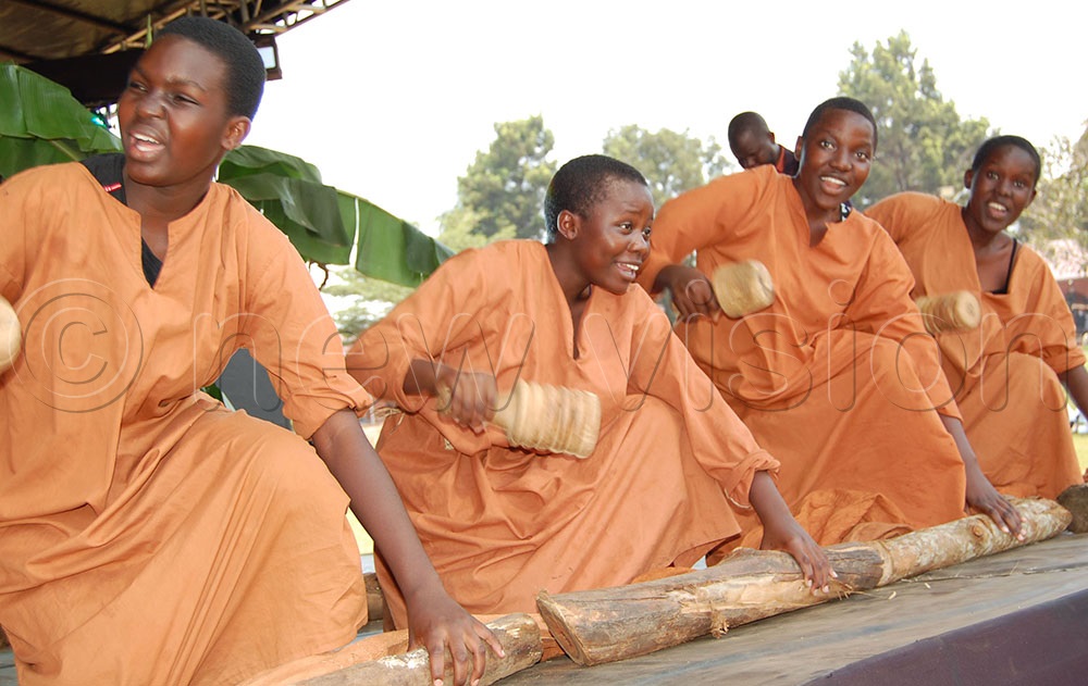Trinity College Nabbingo students deliver a folk musical demonstration of how a bark cloth is made from a Mutuba tree. (Photo by Mathias Mazinga)