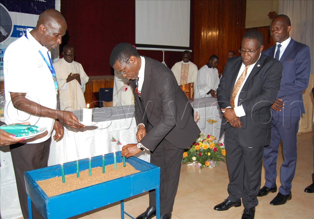 The Katikkiro of Buganda, Charles Peter Mayiga lights a candle in memory of the late Benedicto Kiwanuka. 