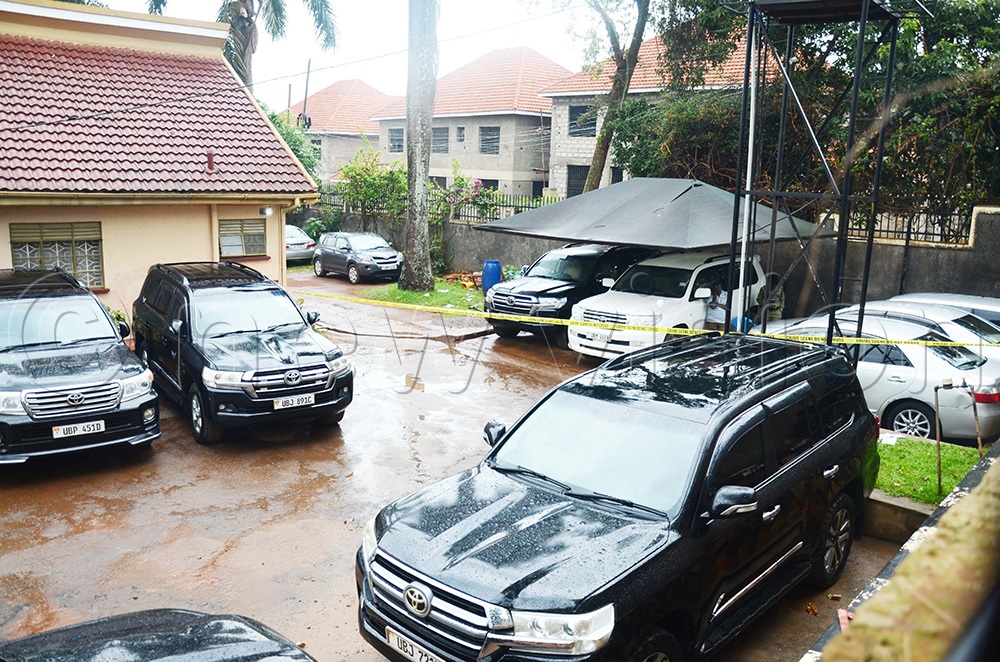 The police officers who were investigating circumstances surrounding death of Anthony Mutinisa of Mutinisa Motors in Ntinda in the parking lot. (Photo by Isaac Nuwagaba)
