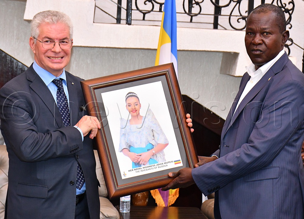 Algerian Ambassador to Uganda Mourad Amokrane (left) receiving a gift of a portrait of HRH Inhebantu of Busoga Jovia Mutesi from Busoga Kingdom's Martin Tibalira Musomesa (right) while at Kyabazinga's Igenge Palace in Jinja City. (Photo by Donald Kiirya)