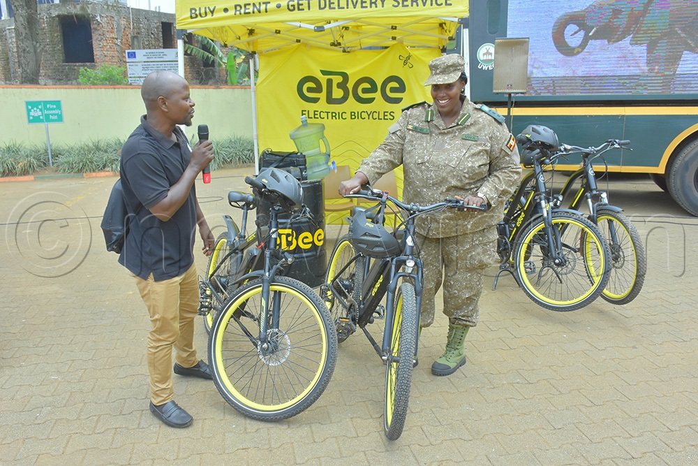 Vanice Mirembe (right), the UWA Manager in charge of conservation education and awareness, inspecting some of the rechargeable bicycles that use clean energy. (Photo by Julius Luwemba)