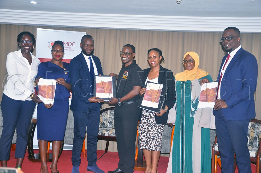 Nakanwagi (Second Left), Ncube (Third Left), Morris (Centre) and other officials holding copies of the report on the governance and sustainable mineral resource management in Uganda and its alignment with the African Mining Vision. This was at the Sheraton Hotel, Kampala. (Photo by John Odyek)
