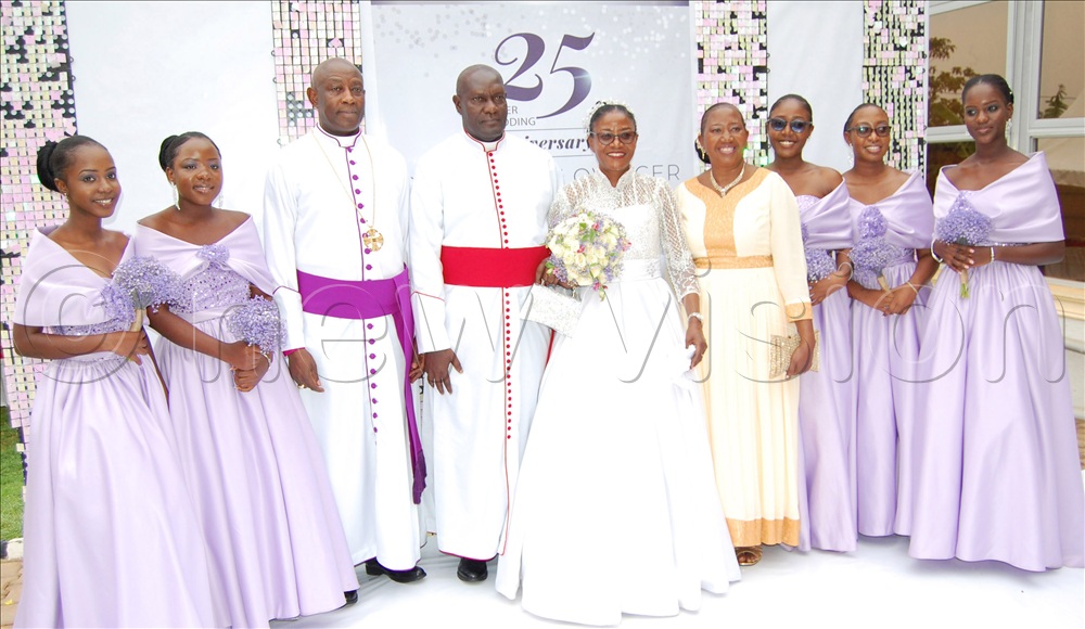 The Kiwanukas (4th and 5th left) share a photo moment with their Bestman Archbishop Samuel Stephen Kaziimba Mugalu (third -left), their Matron Eroni Jjunju (sixth-left) and their bridesmaids upon arrival at their reception venue at Mengo Senior School.