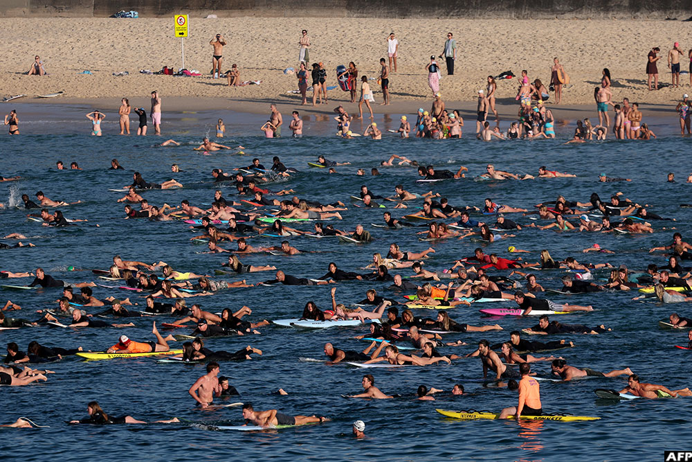  In Sydney, surfers and swimmers paddle and swim together at Bondi Beach as they participate in a tribute to the victims of the December 14 Bondi Beach shooting attack.