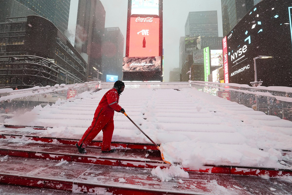  A worker clears the snow on the Red Steps in Times Square during a winter storm in the Manhattan borough of New York City on February 23, 2026. (Photo by TIMOTHY A.CLARY / AFP)
