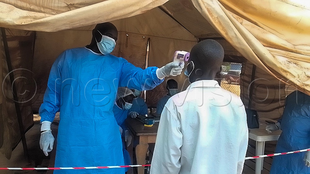 A health worker at Vurra Customs Border point checking the temperature a traveler. (Photo By Robert Ariaka)