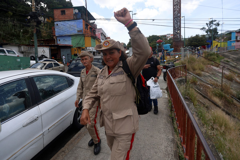 A member of the presidential guard salutes during an orientation day for people who signed up for the Bolivarian National Militia recruitment process organized by the government of President Nicolas Maduro outside the 4F military museum in Caracas, on August 23, 2025. (Photo by Pedro MATTEY / AFP)