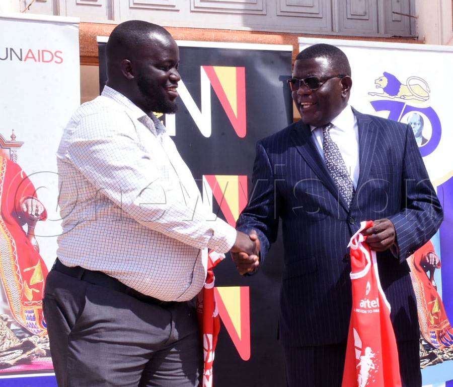 First Deputy Prime Minister Twaha Kaawaase (middle), shakes a hand with Vision Group events supervisor Kennedy Mwota (left) after announcing the 100m sponsorship deal