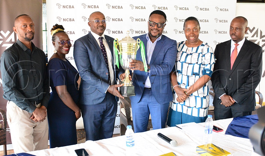 NCBA Bank Uganda Executive Director Julius Konyani (3rd right) and UGC Chairman Board of Directors Paul Nuwagaba (3rd left) display one of the trophies as UGC CEO Farayi Chitengwa (left), Pendeza-Uganda's Christine Walubo (2nd left), UGC captain Gloria Mbaguta and secretary Emmanuel Wamimbi (right) look on during the launch of the NCBA Golf Series at Kitante, June 10 2026. Photo by Michael Nsubuga