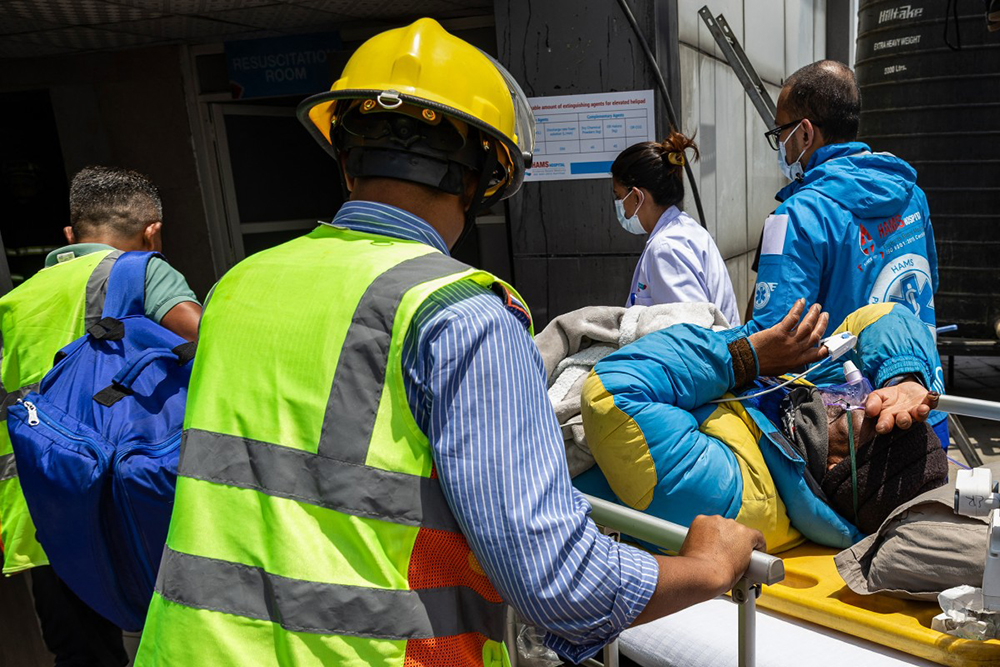 Medics and rescuers carry mountaineer Dawa Sherpa upon his arrival at the HAMS Hospital in Kathmandu on June 4, 2026.