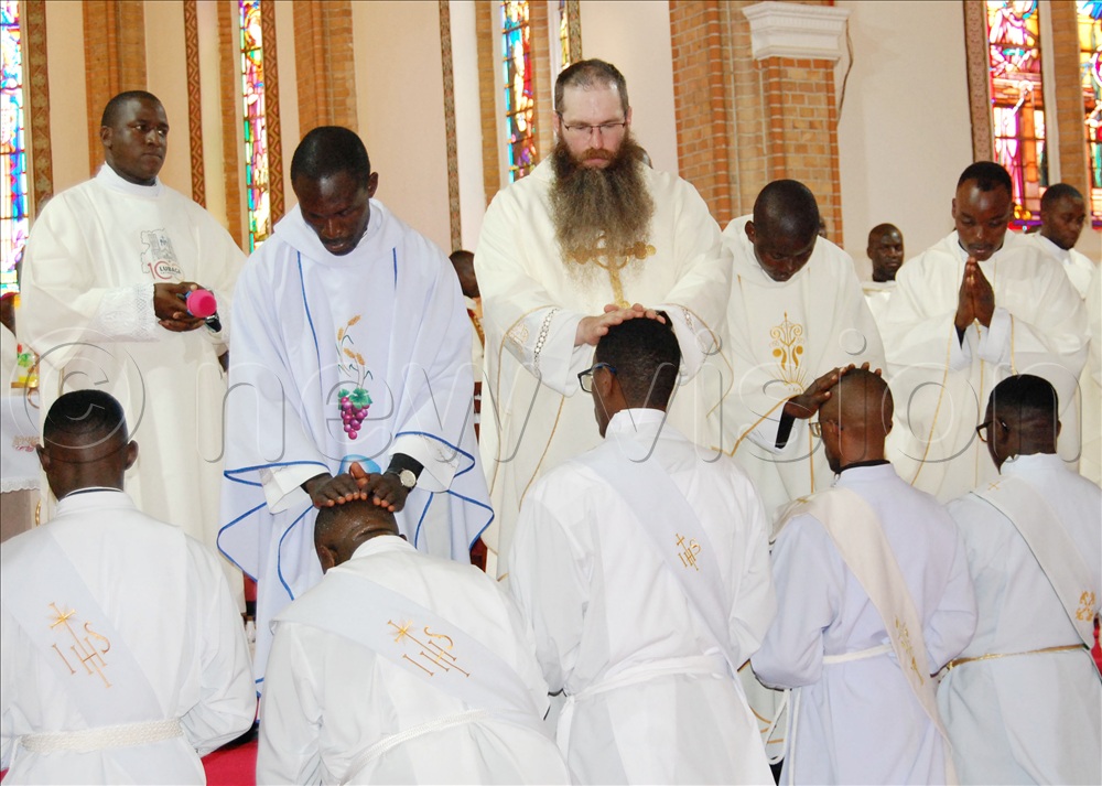 Priests performing the ordination rite of the imposition of hands on the priestly candidates during mass.