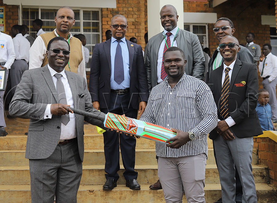 The staff  and old Students of Namilyango College School witness the unveiling of Fred Achelam (R) by the Headteacher of  Namilyango College  as the Cricket team coach. Looking on right is Uganda Cricket Association chairman Jackson Kavuma. PHOTO: Johnson Were