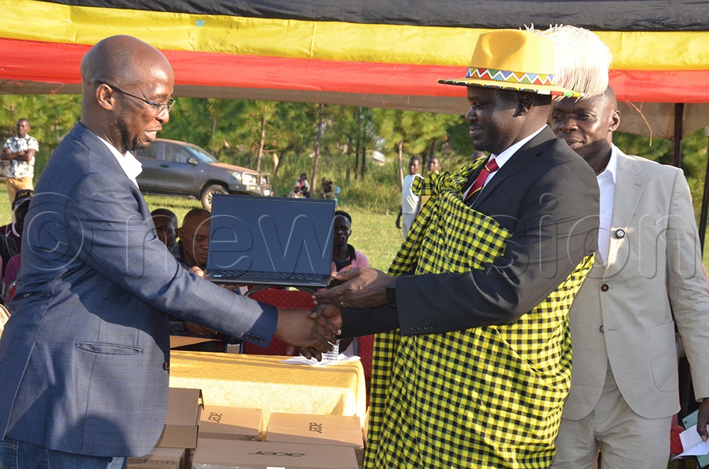 Dr Hatwib Mugasa, the Executive Director of NITA-Uganda (left) handing over a laptop to Andrew Ojok Oulanyah, MP Omoro County, as the State Minister for ICT and National Guidance, Alioni Yorke Odria (extreme right), looks on. (Photo by Jackson Kitara)