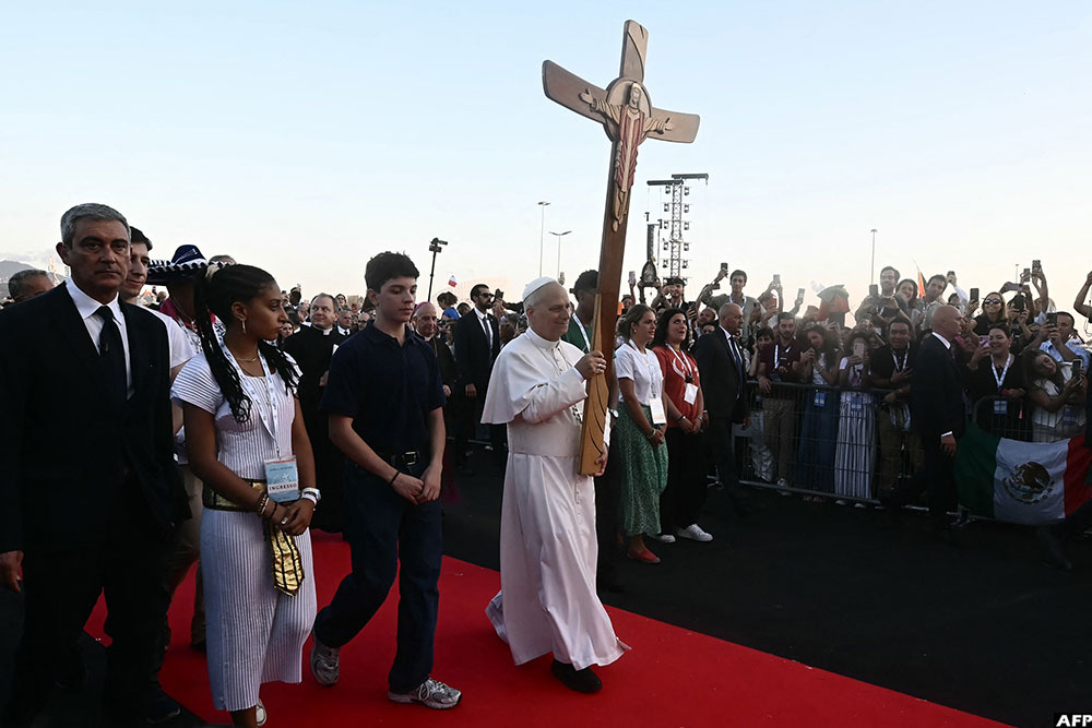 Pope Leo XIV (C) holds the cross as he arrives in Rome's eastern Tor Vergata neighbourhood for a prayer vigil. (AFP)
