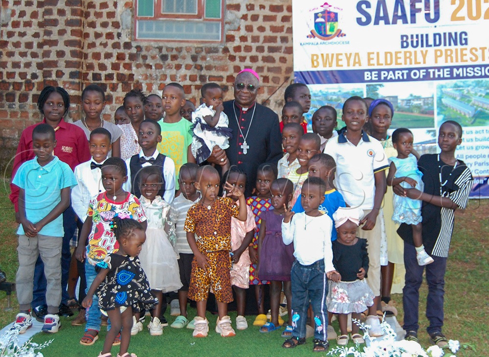 Archbishop Paul Ssemogerere shares a photo-moment with little children who graced the function. (Photo by Mathias Mazinga)