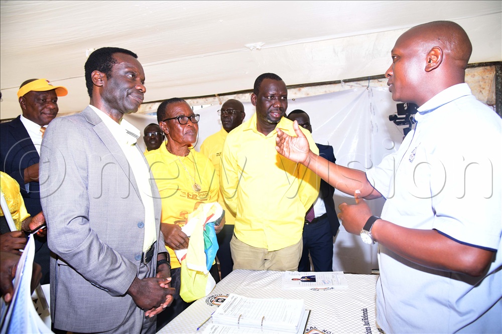 Returning officer John Olinga (right) briefing David Calvin Echodu after nomination as MP for Soroti city west.
