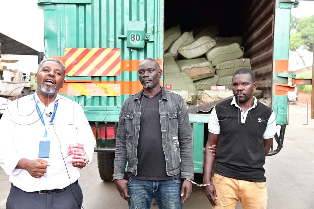Robert Kalumba, Assistant Commissioner for Public and Corporate Affairs and spokesperson for the Uganda Revenue Authority (URA) standing next to the arrested. (Credit: Mpalanyi Ssentongo)