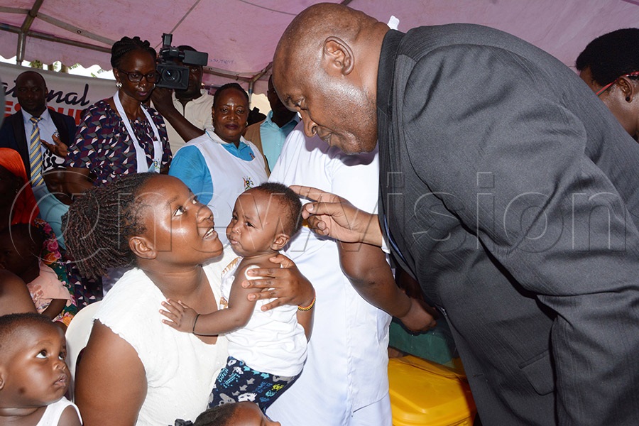 Diana Atwine (right), Permanent Secretary at the Ministry of Health, immunises one-year-old Ivy Amutuhire with the measles-rubella vaccine as her mother, Ritah Atukunda, looks on during the national measles-rubella immunisation campaign at Wakiso Health Centre IV on October 1, 2026. Photo by Mary Kansiime