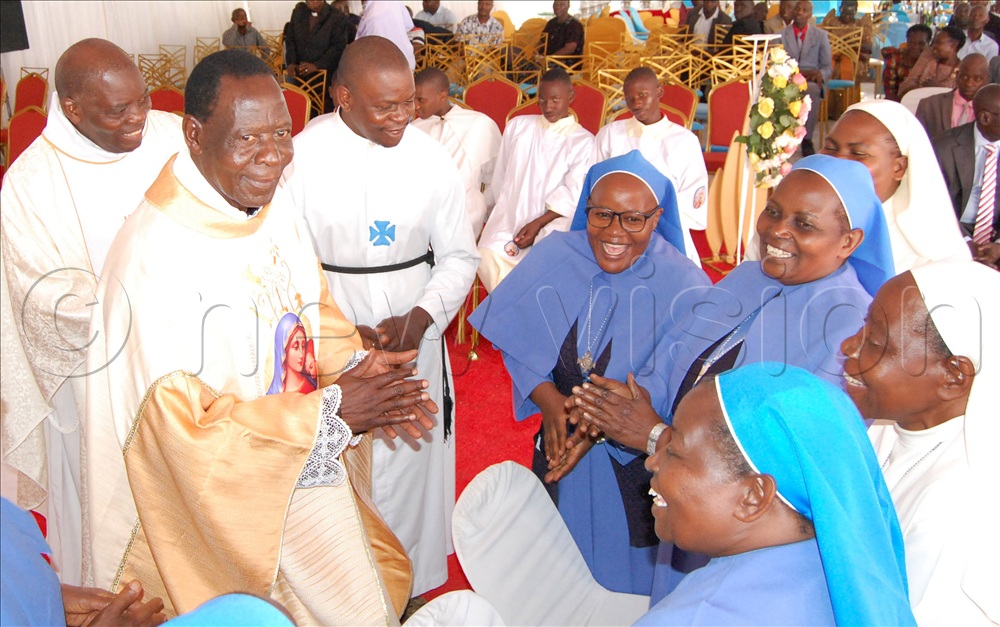 Fr. Denis Kyemwa (second-left) receiving a gift from jubilant clerics and consecrated religious men and women of the Ngeye Clan.