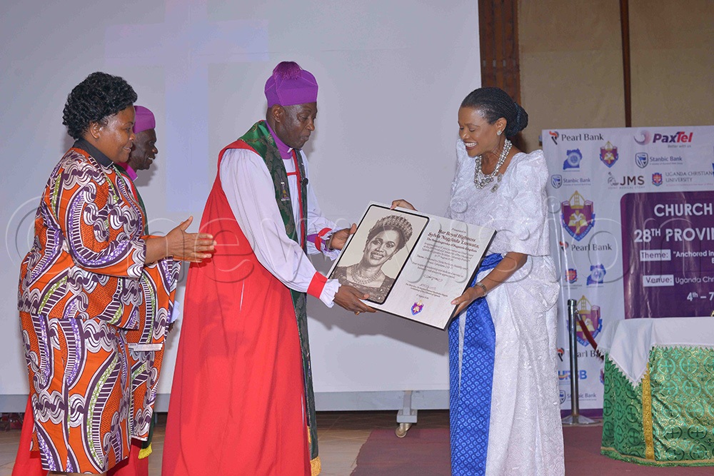 Archbishop of the Church of Uganda, Stephen Samuel Kaziimba, handing over a portrait to the Nnabagereka of Buganda, Sylvia Nagginda, as the Vice Chancellor of Ndejje University, Prof. Olivia Nassaka Bbanja (left), looks on. (Photo by Henry Nsubuga)