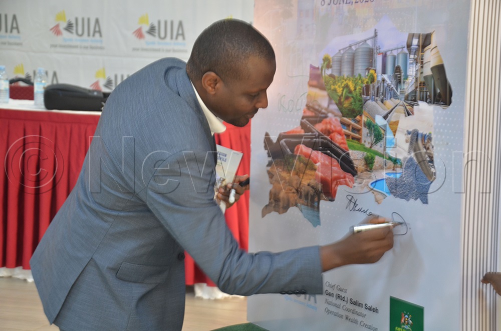 Richard Nuwengesiga, the director of domestic investment, UIA, signing during the launch of the Acholi investment profile. (Photo by Jackson Kitara)