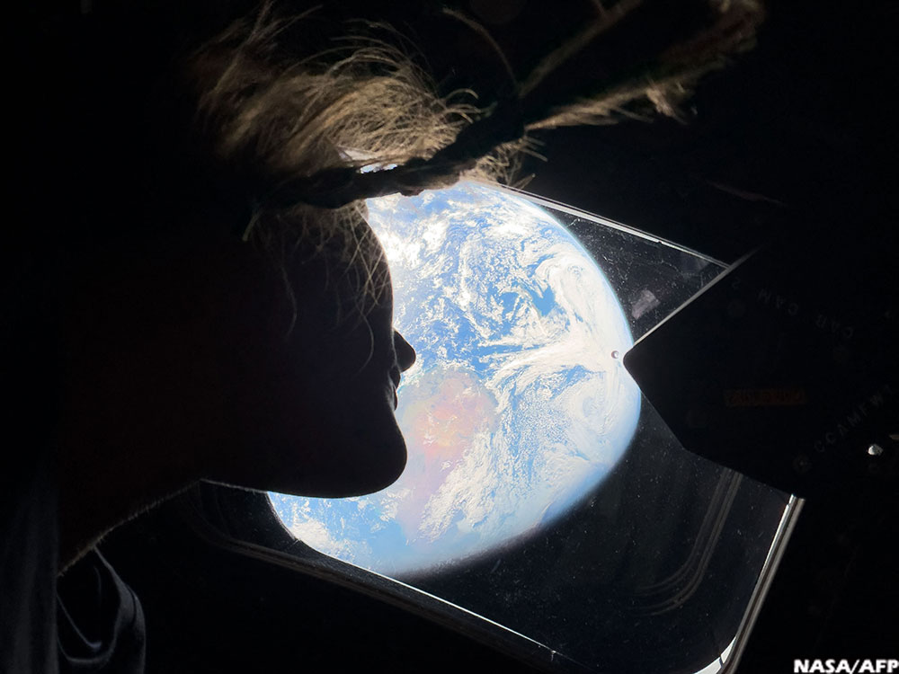 Artemis II mission specialist Christina Koch looking back at earth through the window of the Orion spacecraft on April 2, 2026. (AFP)
