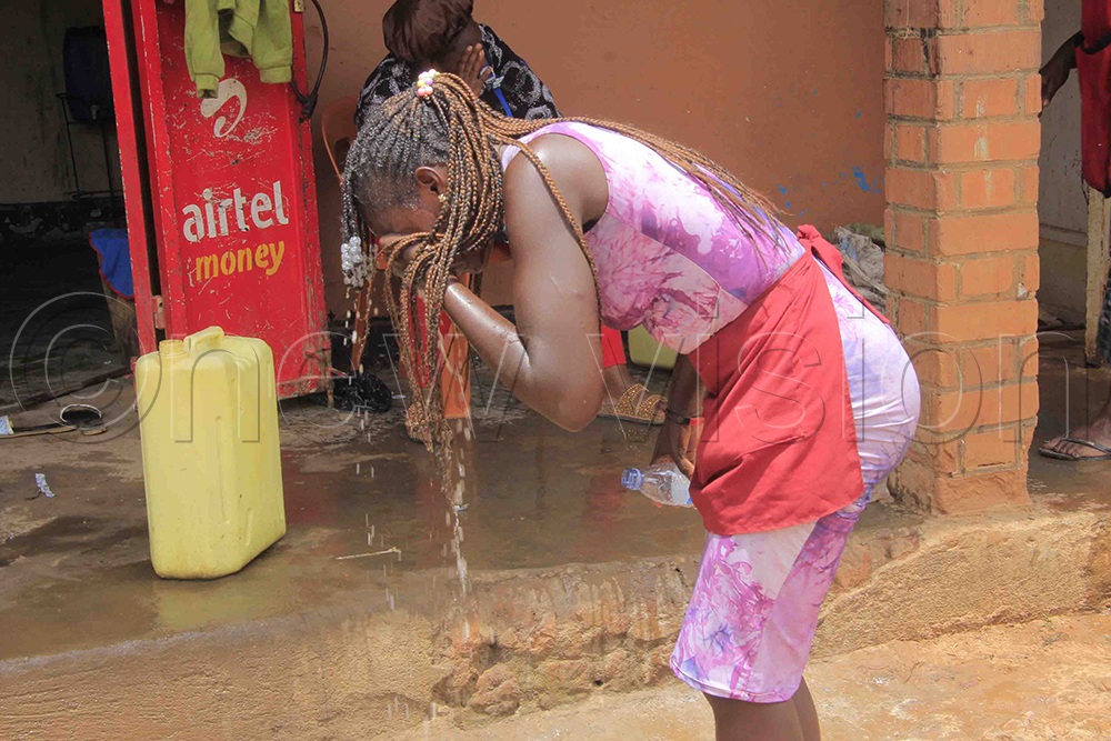 A woman washes her face to relieve irritation after police fired tear gas at residents. (Photo by Wasswa B. Ssentongo)