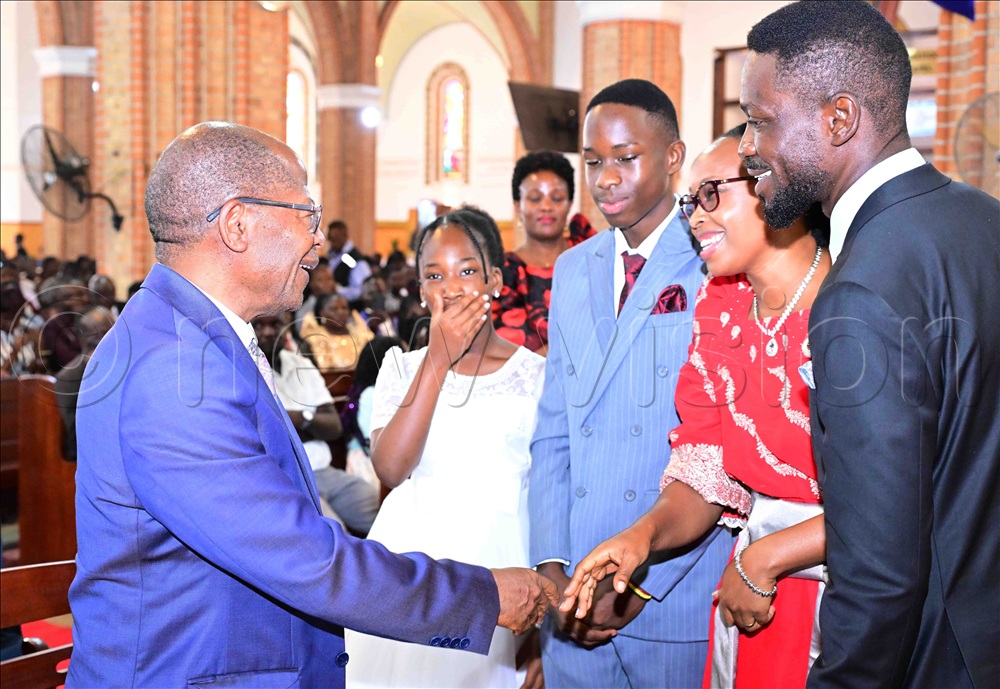 State Minister for higher Education John Chrysestom Muyingo (left) sharing a light moment with NUP Presidential Candidates Robert  Kyagulanyi (right) in the company of Barbie Kyagulanyi and their children. This was before start of the Christmas prayers at Lubaga Cathedral on Thursday, December 25, 2025. 
