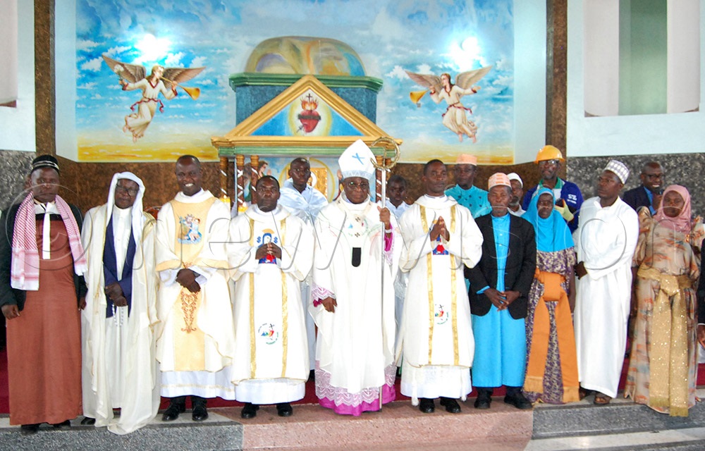 The Archbishop of Kampala Archdiocese, Paul Ssemogerere (holding a crosier) and the parish priest of Bujuuko, Fr. Anthony Bbaale (third-left) share a photo moment with the Muslim clerics who graced the thanksgiving mass for the blessing and dedicaction of St. Charles Lwanga Bujuuko Catholic parish church. (Photo by Mathias Mazinga)