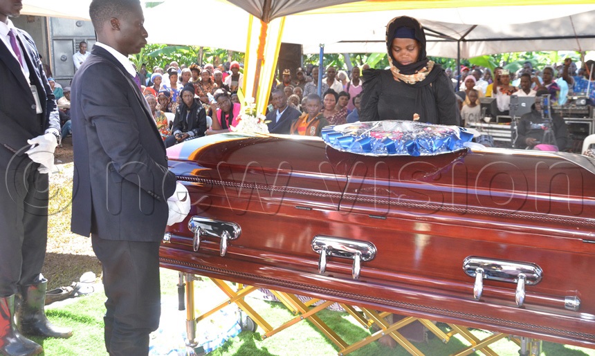 The widow of John Bosco Ssenyonjo aka Bitanda after laying the wreath on the husband's casket. (Photo by Dismus Buregyeya)