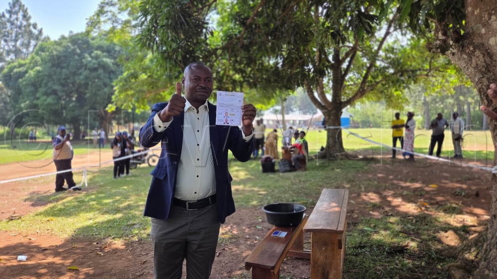 Paddy Kisembo displays his ballot paper after casting his vote. (Credit: Peter Abaanabasazi)