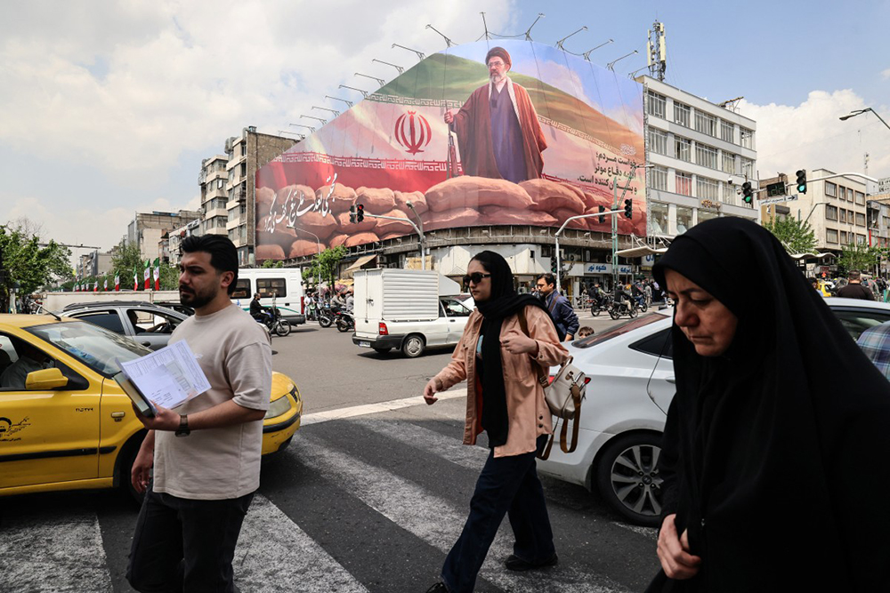 Iranians walk past a large billboard depicting Iran's Supreme Leader Ayatollah Mojtaba Khamenei on a street in Tehran on April 20, 2026. (AFP)