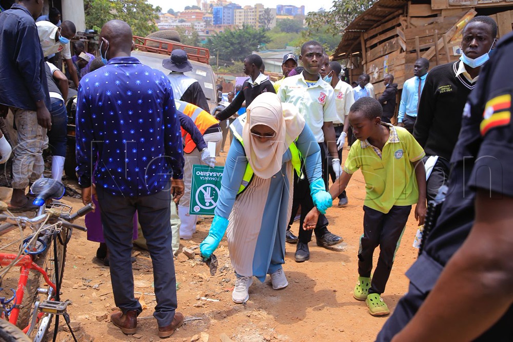 KCCA Executive Director, Sharifah Buzeki, with a young boy during the cleaning exercise. (Credit: Miriam Najjingo)