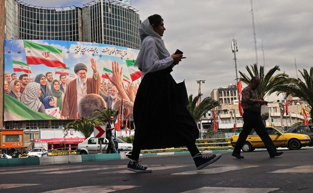 Commuters make their way past a giant billboard of slain Iranian supreme leader Ayatollah Ali Khamenei at the Valiasr Square in Tehran on April 19, 2026. (Credit: AFP)