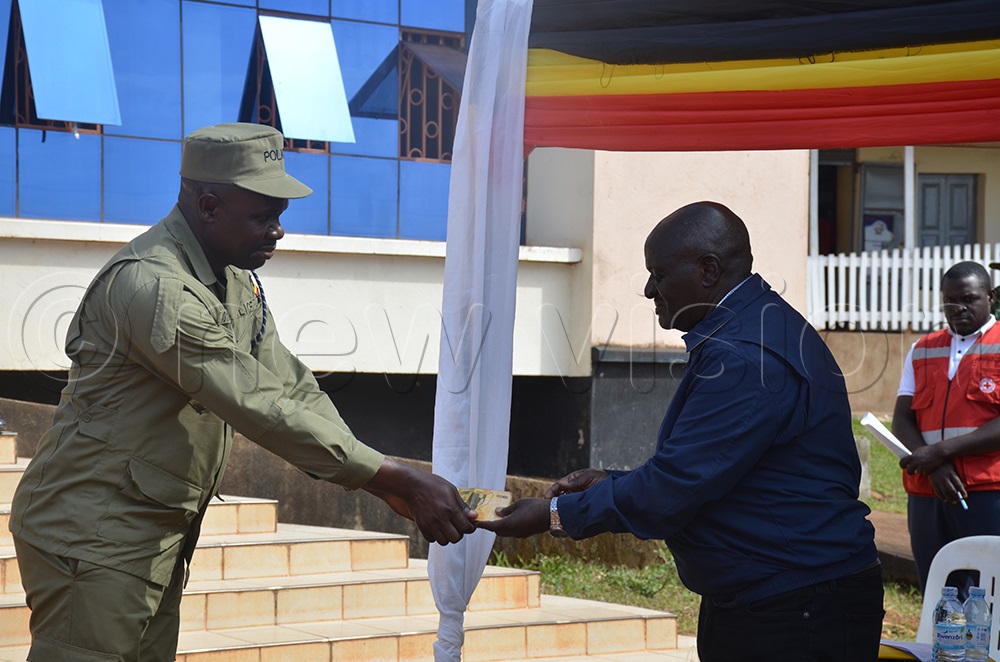Gen. Edward Katumba Wamala delivering sh5m to a family member of Police officer who lost life in the storm that hit Kalangala. (Photo by Samuel Nkuba)