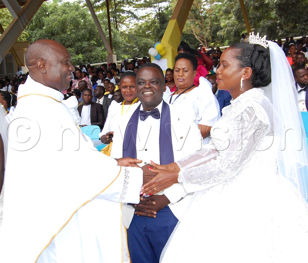 Msgr. Lawrence Ssemusu congratulates one of the couples that he wedded during the celebration of the International Day of the Family at Uganda Martyrs Catholic Shrine, Namugongo on Saturday, May 16, 2026. (Photo by Mathias Mazinga)