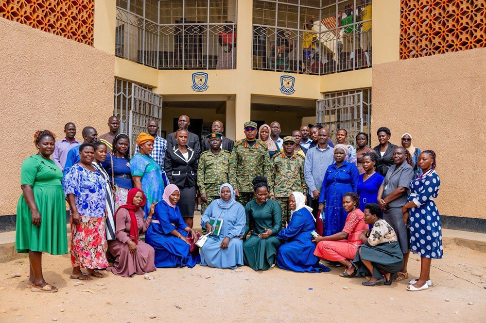 The Joint Staff Formal Education, Sports and Culture, Brig Gen Richard Karemire and CDF’s Military Assistant, Col Christopher Muwumba in a group photograph with Bombo Barracks Nursery and Primary School staff. (Credit: UPDF)