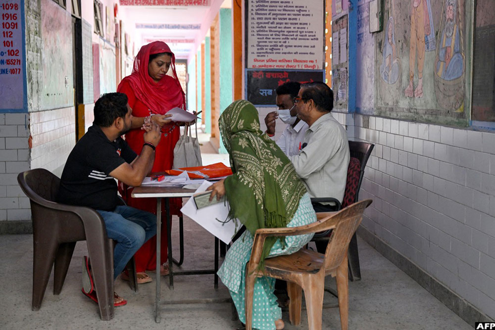 Booth level-officer (BLO) Mukesh Khanna (R) assists people to register their documents for the Draft Electoral Roll 2026 on October 18, 2026. (AFP)