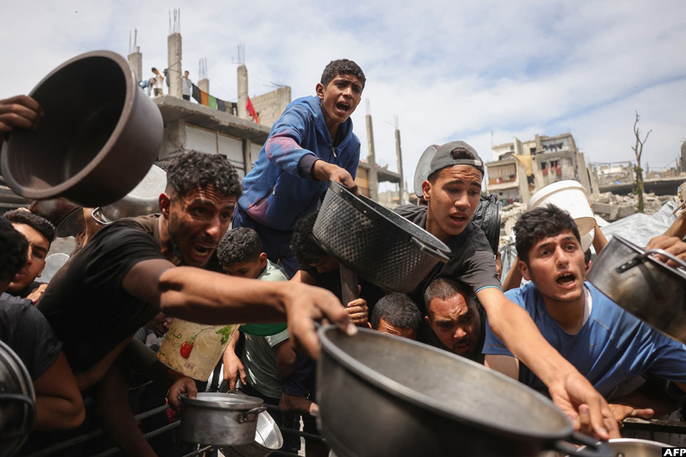 Palestinians struggle to get their food rations outside a crowded distribution centre in Beit Lahia in the northern Gaza Strip on May 15, 2025