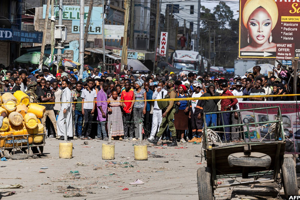 Police enforce a cordon to keep curious residents from mobbing the site of the collapsed building in Eastleigh. (AFP)