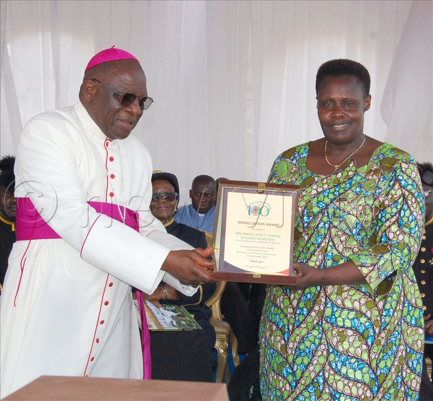 Archbishop Paul Ssemogerere hands over to Vice-President Jessica Alupo the accolade that the Brothers of Christian Instruction gave to President Yoweri Museveni.