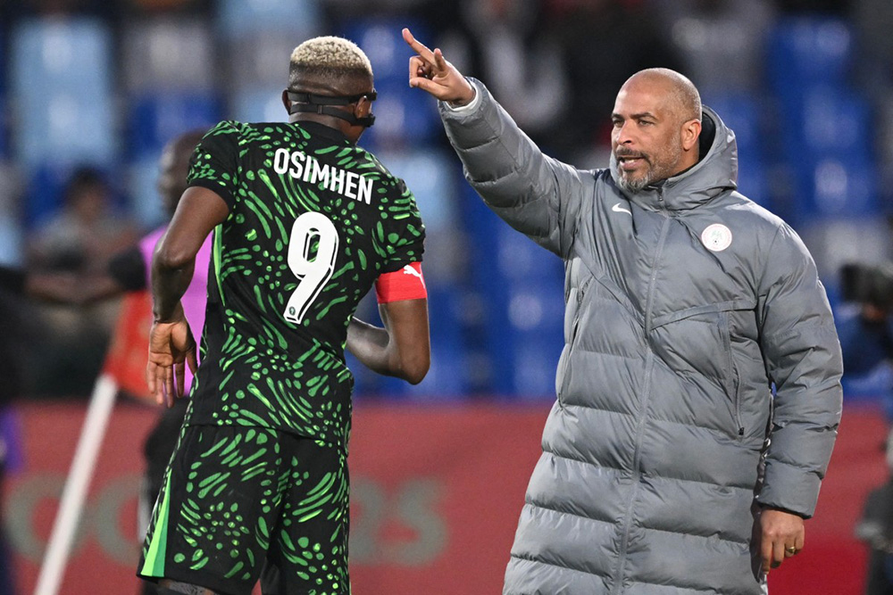 Nigeria's head coach Eric Chelle speaks to Nigeria's forward #09 Victor Osimhen during the Africa Cup of Nations (CAN) quarter-final football match between Algeria and Nigeria at the Grand stadium in Marrakesh on January 10, 2026. (Photo by SEBASTIEN BOZON / AFP)